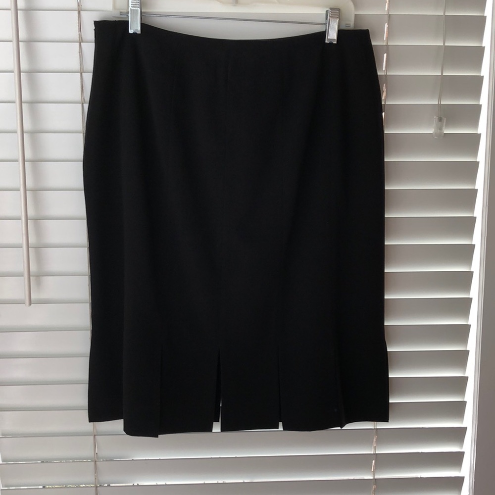 Black lined skirt with kick pleats all around.